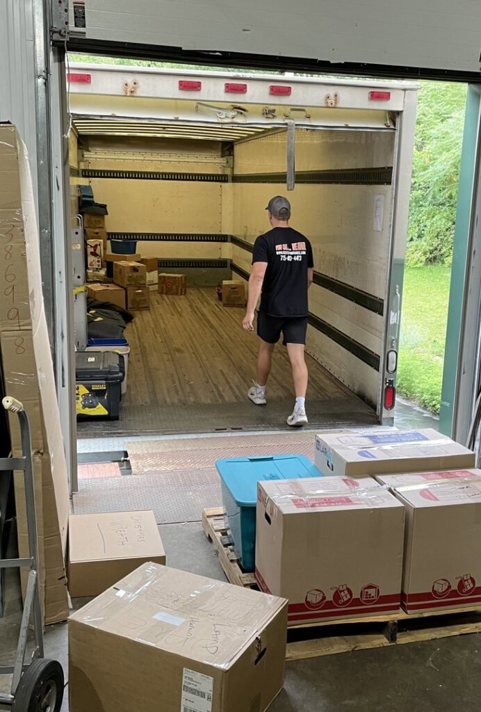 A professional mover from Next Step Moving walking into an empty truck, with packed boxes ready for loading in Eau Claire, WI.