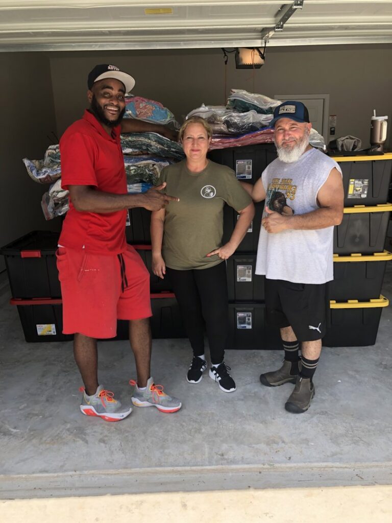 A mover from allpromovingservice with customers in a garage, surrounded by moving bins in San Antonio, TX.