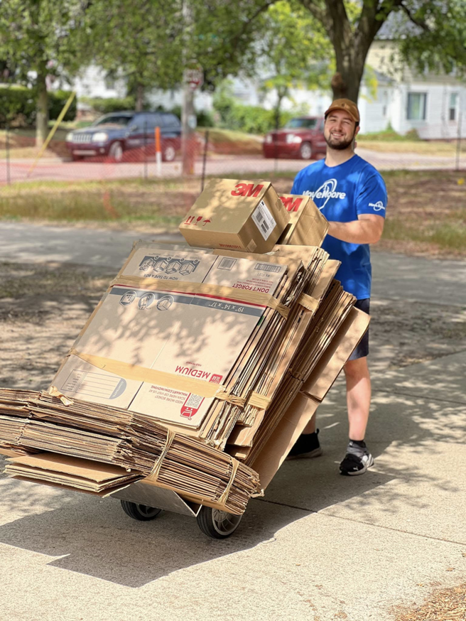 A Move Moore team member pushing a hand truck loaded with moving boxes in Grand Rapids, MI.