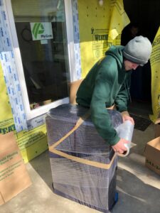 A mover from Emerald Moving & Storage, Inc. professionally wrapping furniture for transport in Eugene, OR.