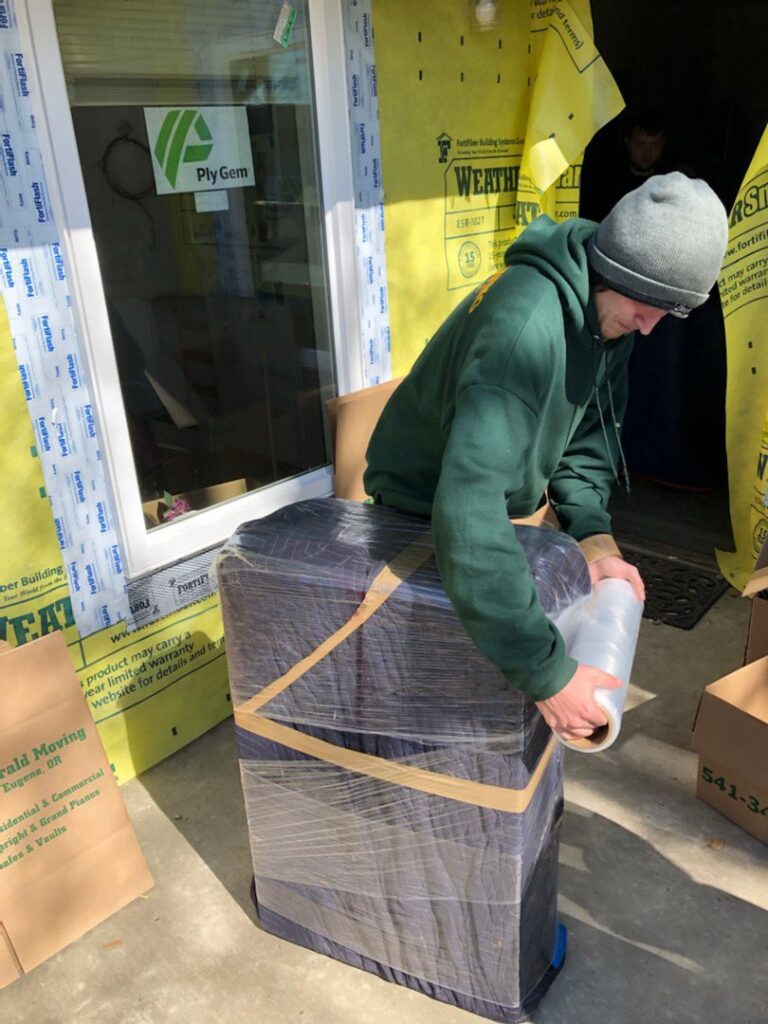 A mover from Emerald Moving & Storage, Inc. professionally wrapping furniture for transport in Eugene, OR.