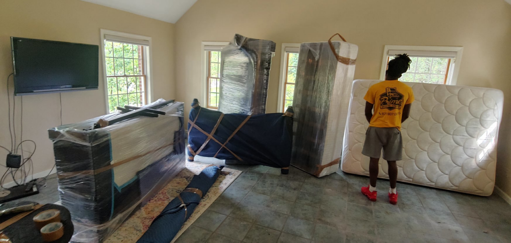A Prime Moving Center employee with furniture wrapped and ready for transport in Pittsburgh, PA.