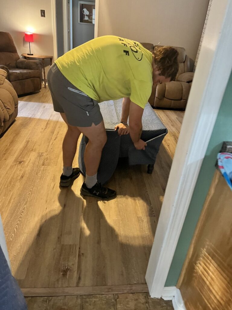 A Jubilee City Movers team member wrapping furniture with a protective moving blanket in Montgomery, AL.