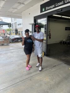 Two movers from allpromovingservice standing outside a storage unit facility in San Antonio, TX.