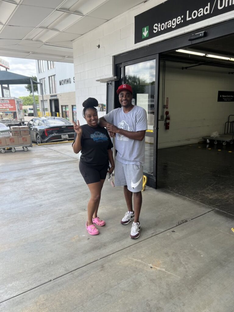 Two movers from allpromovingservice standing outside a storage unit facility in San Antonio, TX.