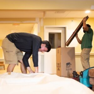 Two Mastodon Moving LLC movers carefully handling a large item during a move in Westborough, MA.