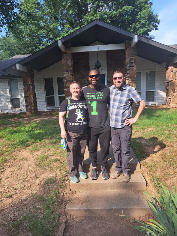 Three movers standing in front of a house for Coach Carter Fitness at BLB Training Next level in Fayetteville, AR