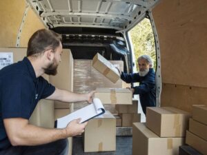 Professional movers loading boxes into a van while checking a list for Las Vegas Moving Pros LLC in Las Vegas, NV.