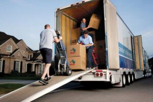 Professional movers loading moving boxes onto a truck at a residential location for Capital Relocation Group in Raleigh, NC.