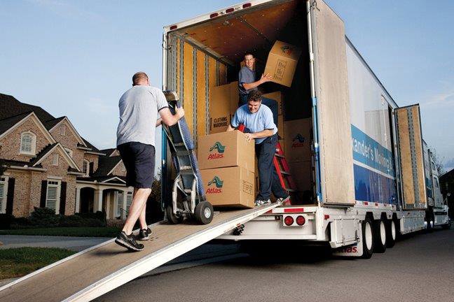Professional movers loading moving boxes onto a truck at a residential location for Capital Relocation Group in Raleigh, NC.