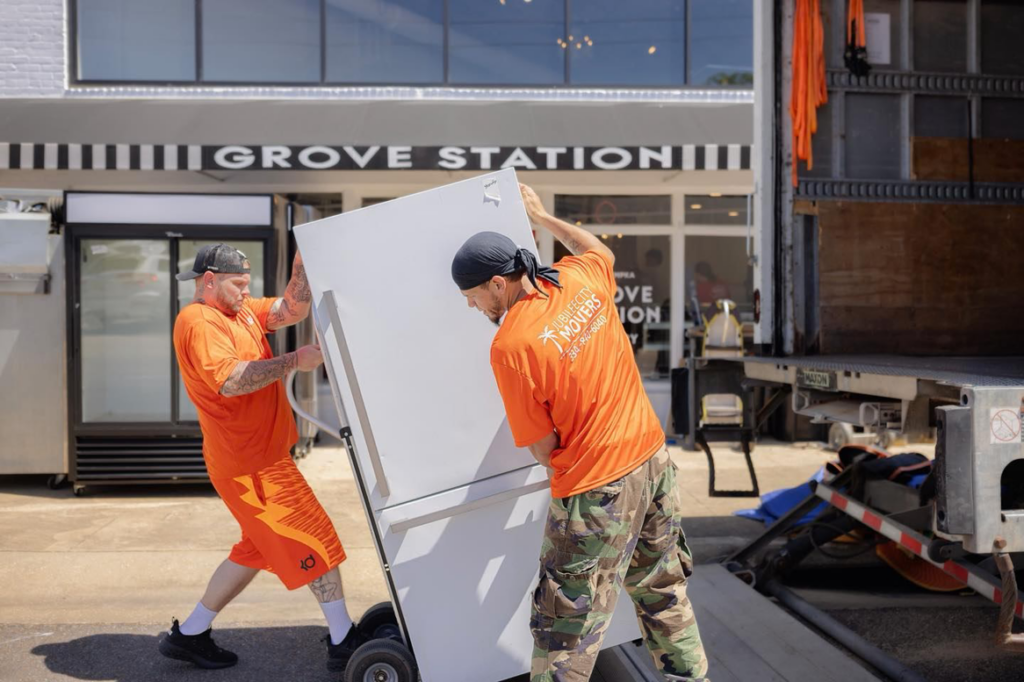 Two Jubilee City Movers team members loading a large refrigerator onto a truck in Montgomery, AL.