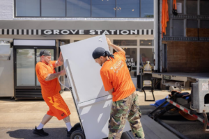 Two Jubilee City Movers team members loading a large refrigerator onto a truck in Montgomery, AL.