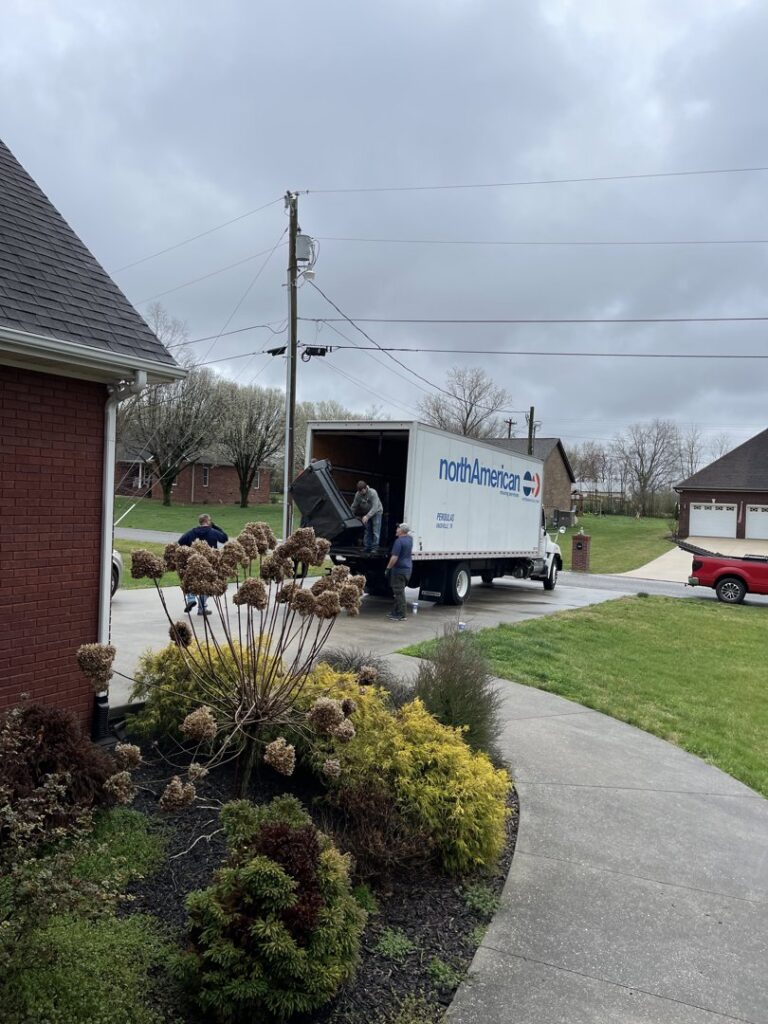 Movers loading a North American moving truck at a residential property, provided by Peroulas Moving and Storage in Knoxville, TN