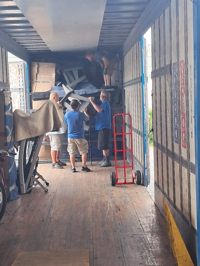 Professional movers efficiently loading items inside a moving truck, showcasing services by Peroulas Moving and Storage in Knoxville, TN