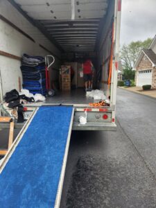Movers loading items into a Family Movers 615 LLC truck using a ramp, ready for a job in Goodlettsville, TN.