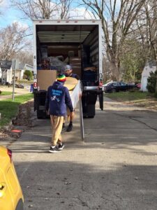 Two Top Notch Movers employees loading items onto a moving truck using a ramp in Madison, WI.
