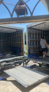 Movers from Gifted Hands Moving & Storage in Collierville, TN, efficiently loading items between two moving trucks.