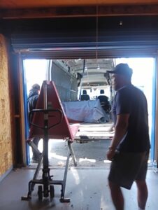 Professional movers loading items into a van using a pallet jack for Rough Çutt Movers in San Diego, CA