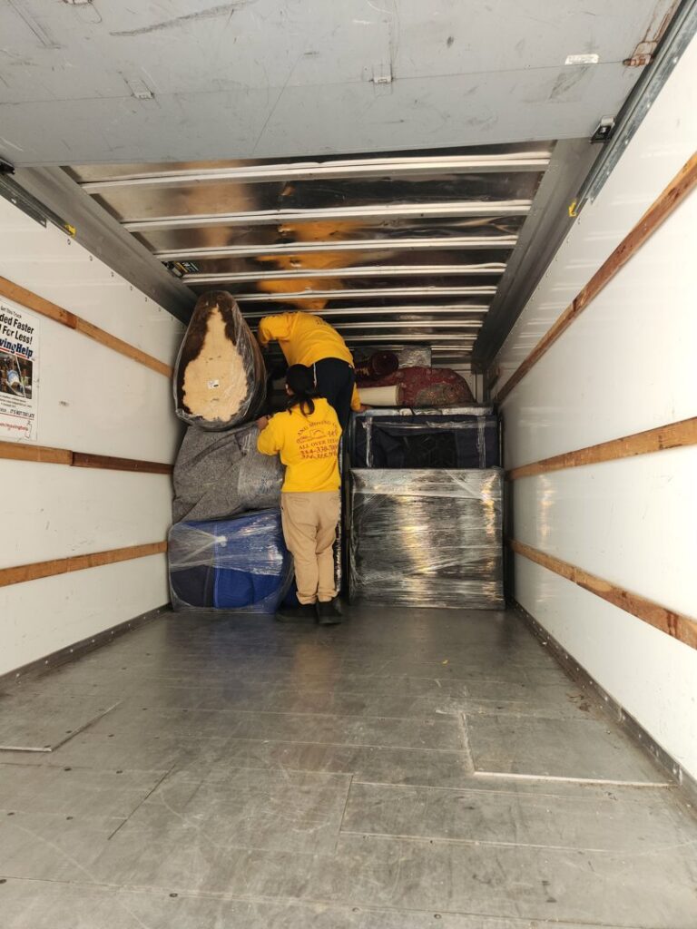 Ang Moving Co movers loading wrapped furniture and boxes into a moving truck in Dallas, TX