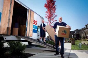 Movers unloading boxes from a moving truck at a residential home for Capital Relocation Group in Raleigh, NC.