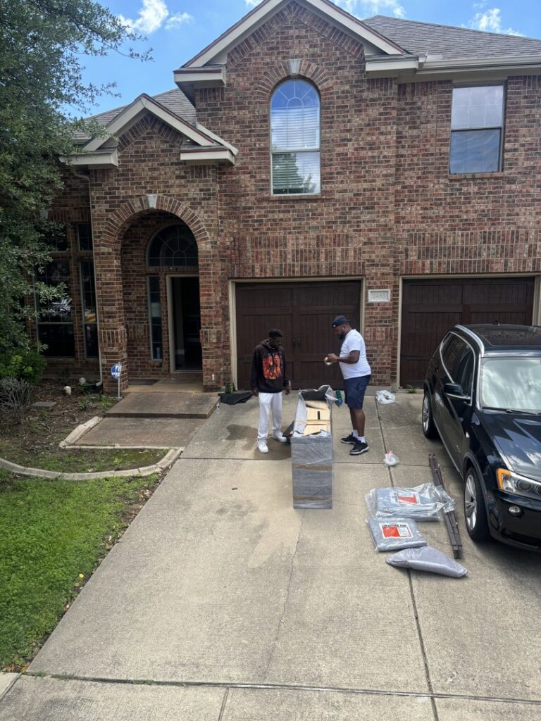 Two Advantage Express Movers team members preparing to move a large, wrapped item on a residential driveway in Arlington, TX.