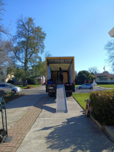 Professional movers unloading a truck with a ramp for Rough Çutt Movers in San Diego, CA