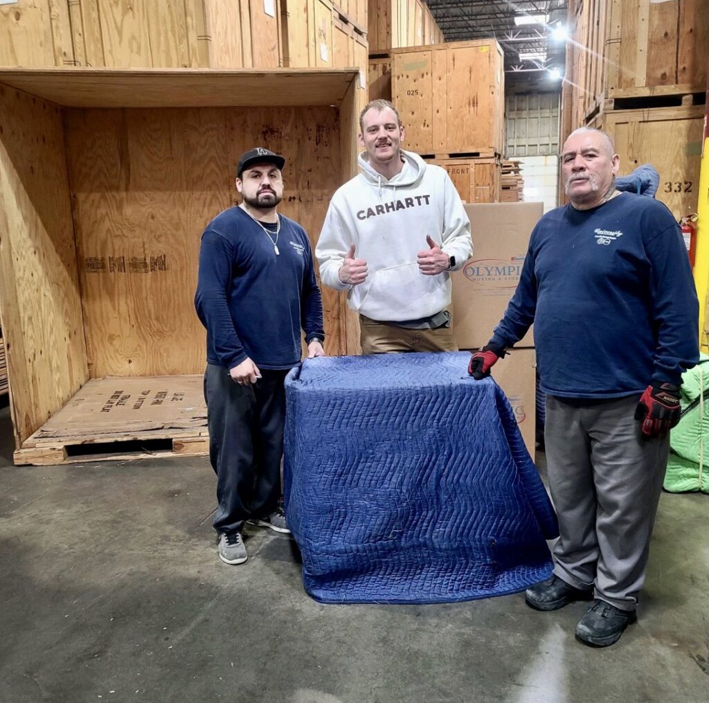 Move Moore team members with a padded item in a storage facility in Grand Rapids, MI.