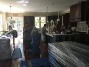 TruMoving movers carefully wrapping furniture in a client's kitchen during a move in Lakewood, CO.