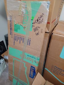 Stacked moving boxes, including Lowe's brand, packed and ready for transport by Packsen Moving in San Antonio, TX.