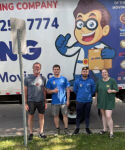 A happy moving crew giving thumbs up in front of a Let's Get Moving truck in Saint Petersburg, FL.