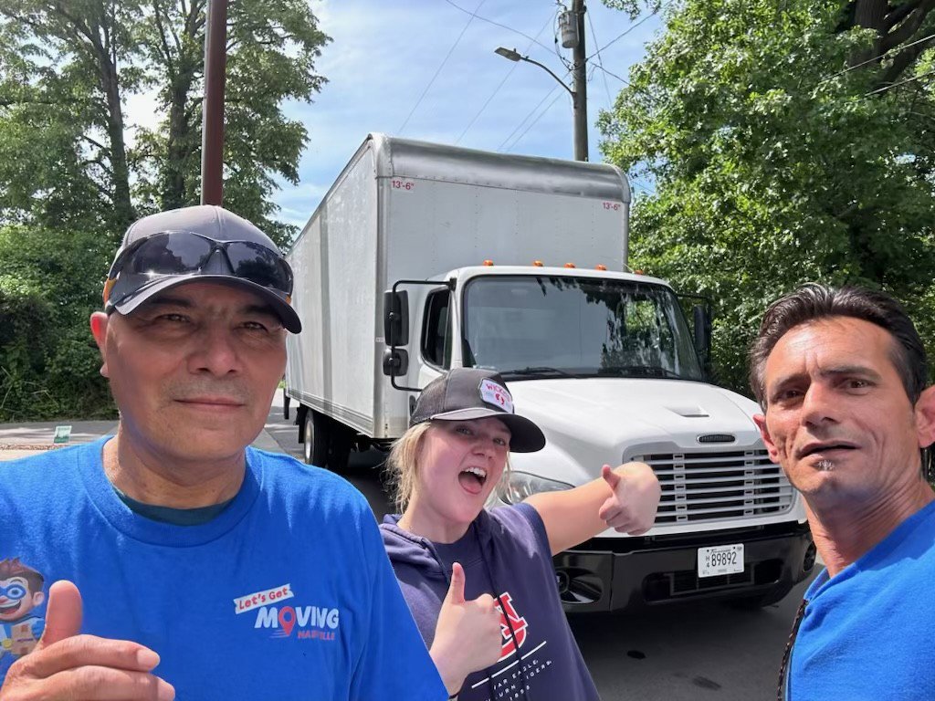A moving team giving thumbs up in front of a white moving truck for Let's Get Moving in Saint Petersburg, FL.