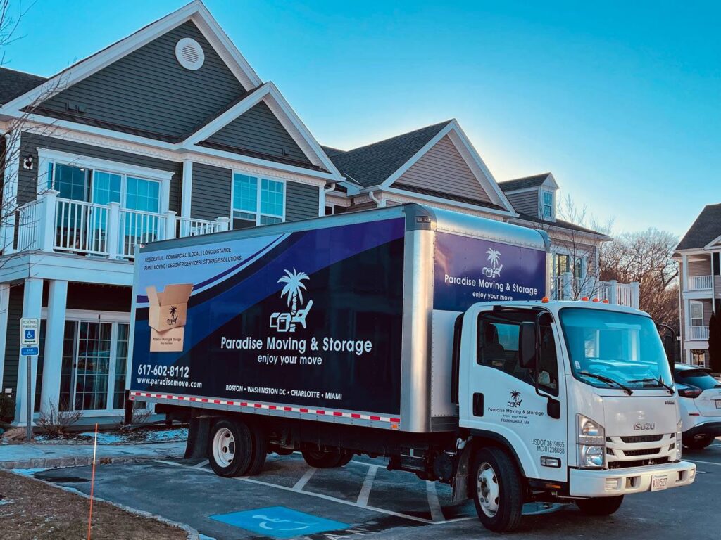 A Paradise Moving & Storage truck parked in front of an apartment complex in Boston, MA.