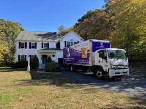 A Paradise Moving & Storage truck parked in front of a house on a sunny day in Boston, MA.