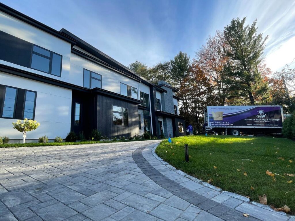 A Paradise Moving & Storage truck parked in front of a modern house in Boston, MA.