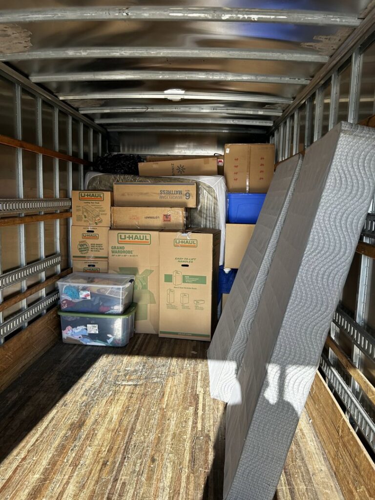 A moving truck interior fully loaded with various moving boxes and a mattress by The Knoxville Moving Co. in Knoxville, TN.