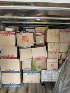 A moving truck interior filled with various cardboard boxes and furniture, expertly loaded by E.L.I Movers LLC in Houston, TX.