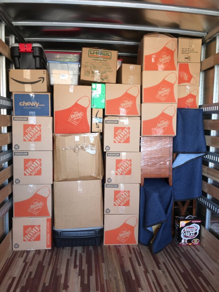The interior of a moving truck meticulously packed with various boxes and protective moving blankets by Academy Movers in Gilbert, AZ.
