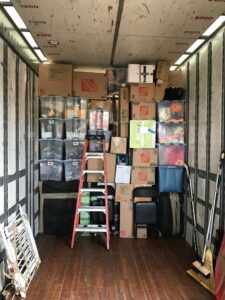 The interior of a J.Gentle Van Lines moving truck, fully packed with various boxes and a ladder, ready for transport in Elizabeth, NJ.