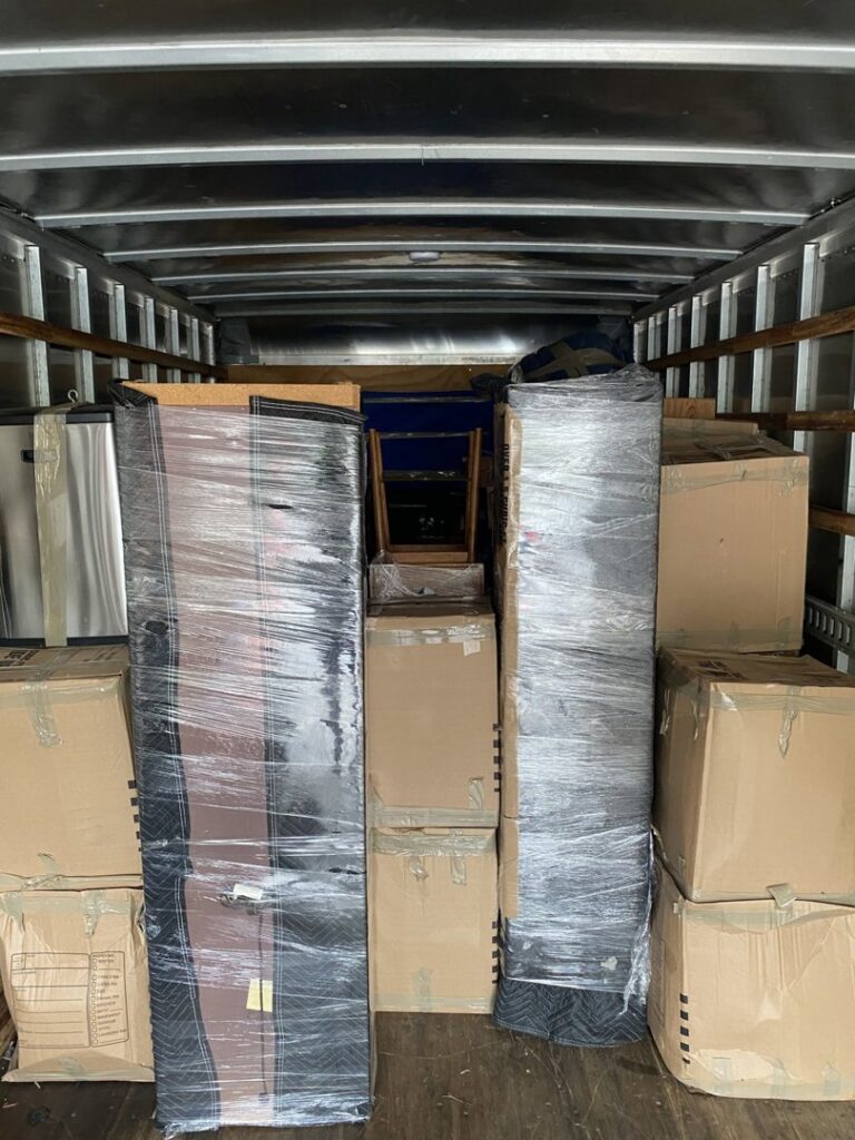 The interior of a moving truck packed with boxes and wrapped items by Rambling Man Logistics in Hildebran, NC.