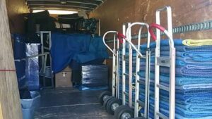 The interior of an Ang Moving Co truck packed with furniture, boxes, and moving blankets in Dallas, TX