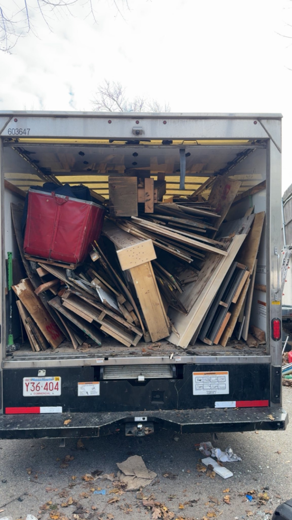 A Mighty Movers truck loaded with construction debris and junk for removal in Marlborough, MA.