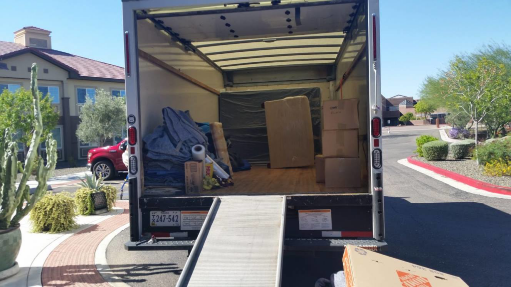 A moving truck being loaded with boxes and blankets near a storage unit by Monty's Movers in Fairfax, VA.