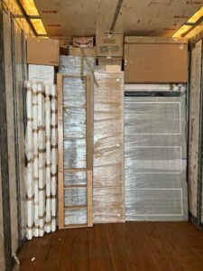The interior of a J.Gentle Van Lines moving truck, efficiently packed with doors and various wrapped items in Elizabeth, NJ.