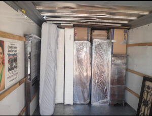 The interior of a moving truck packed with wrapped mattresses, dressers, and boxes by Advantage Express Movers in Arlington, TX.