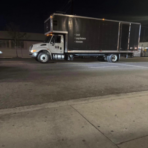 A large moving truck from Cheney Brothers Moving Company parked on a street at night in Fort Lauderdale, FL.