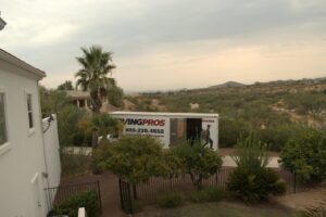 A Moving Pros LLC truck parked outside a residential house in Surprise, AZ, ready for a move.