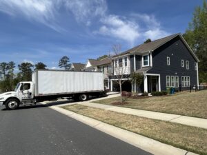 A large moving truck parked in front of townhouses, ready for a job by Rambling Man Logistics in Hildebran, NC.