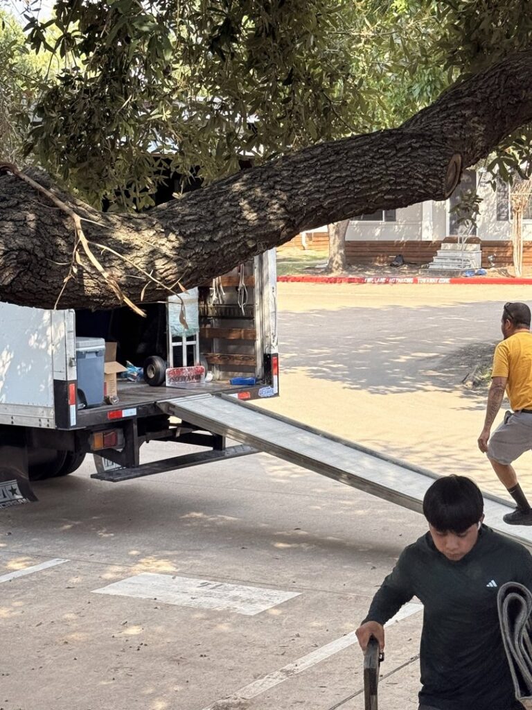 A moving truck with its ramp extended, ready for loading or unloading, with movers nearby from Houston Affordable Movers in Houston, TX.