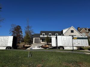 Two large moving trucks parked outside a residential house, indicating a moving job by The Knoxville Moving Co. in Knoxville, TN.