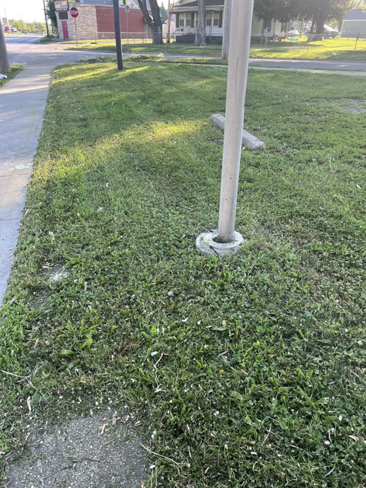 Mowed grass with visible clippings near a utility pole, indicating recent lawn care by Vick's Lawn Care Service in Des Moines, IA.